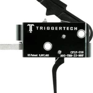 Close-up of a TriggerTech rifle trigger mechanism: black metal housing with a safety lever and mounting blade.
