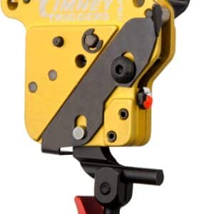 Yellow mechanical archery release trigger with black adjustment lever and red safety toggle, mounted on a stand.