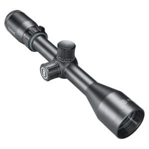 Bushnell rifle scope with adjustable turrets and objective lens shown from angle.