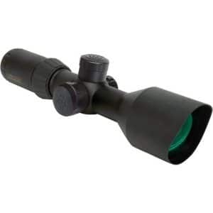 Black rifle scope with green-tinted objective lens and adjustment turrets on a matte finish
