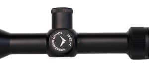 Black riflescope with a blue accent ring near the eyepiece, center adjustment dial, and a large objective end viewed in profile