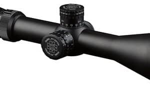 Black riflescope with three adjustment turrets and a green-tinted objective lens viewed from the side.