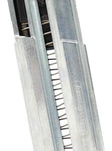 Metal staple gun with a loaded magazine and visible staples in the track segment, ready for use in upholstery.