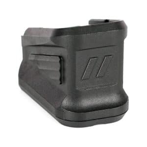 Black rectangular polymer battery pack with a side latch and two diagonal raised marks on the rear face (cordless tool battery).