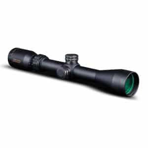 Black riflescope with green-tinted objective lens and adjustment turrets, photographed on white background (product shot)