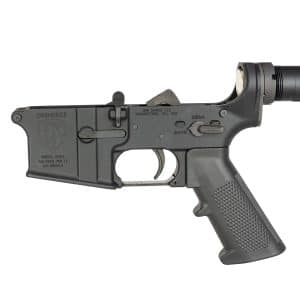 Close-up of a black AR-style rifle lower receiver with trigger, safety selector, and pistol grip against a white background.