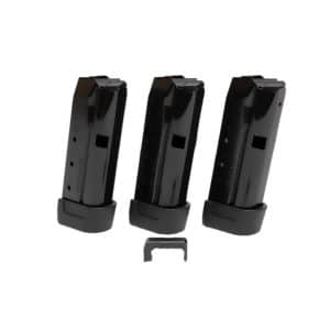 Three black handgun magazines standing upright on a white background, arranged in a row with a small component below them.