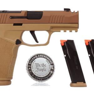 Tan-colored semi-automatic pistol with a black slide, two magazines with orange followers nearby, and a decorative medallion reading 'We the People' beside it.