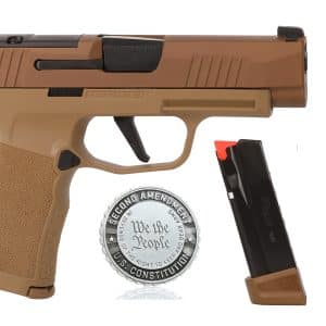 Side view of a tan SIG Sauer handgun with two magazines nearby and a round commemorative coin beneath it.