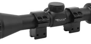 Black riflescope with adjustment knob, mounted on two scope rings attached to a rail surface for a firearm setup