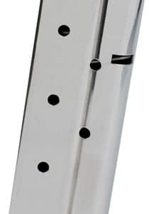 Metal pistol magazine with five witness holes and a black base plate, viewed from an angle.