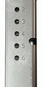 Metal handgun magazine with numbered holes 2–6 and a black baseplate.