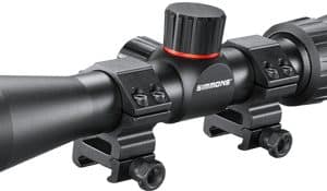 Black riflescope with mounting rings and a red adjustment knob on a rail