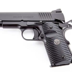 Close-up side view of a black semi-automatic pistol showing the slide, serrations, and textured grip (Wilson Combat).
