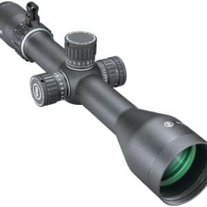 Black Bushnell rifle scope with four adjustment turrets and a green-tinted objective lens, mounted for aiming far targets.