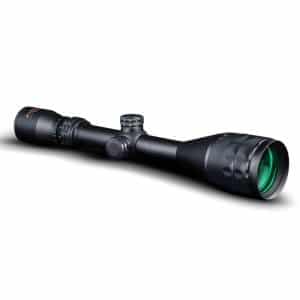 Black riflescope with green-tinted objective lens and knurled adjustment turrets on a white background