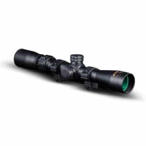 Black matte riflescope with two mounting rings and knurled adjustment knobs, angled to the left.