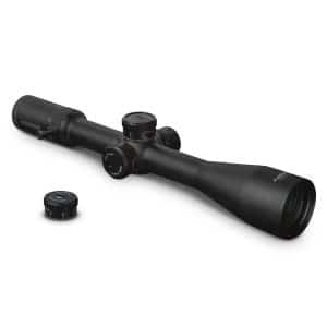 Black rifle scope with adjustment dials and a separate lens cap resting nearby on a white background
