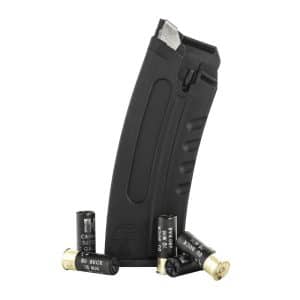 Black plastic firearm magazine standing upright with several 00 buckshot shotgun shells scattered around it.