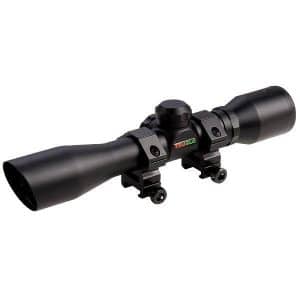 Rifle scope with mounting rings and scope adjustment knob, angled shown against white background (weapon optics accessory).