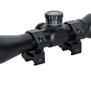Black riflescope with two mounting rings and adjustable turrets, Mil-Dot reticle symbol shown in the bottom-right corner.