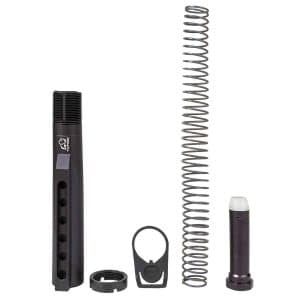 Airsoft upgrade kit showing a long cylindrical outer tube, a tall compression spring, a small nozzle piece, a circular end cap, a mounting clip, and a small black connector piece.