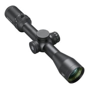 Close-up of a black Bushnell rifle scope with knurled adjustment knobs and lens at the front edge