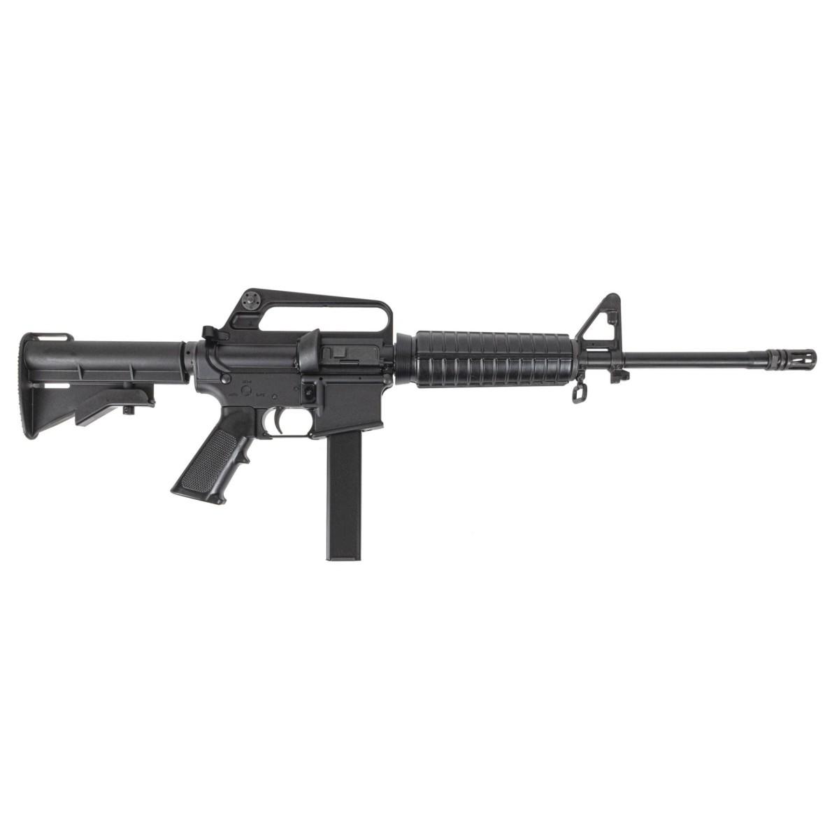 Black AR-style rifle with a vertical magazine and fixed stock, photographed from the left side on a white background.